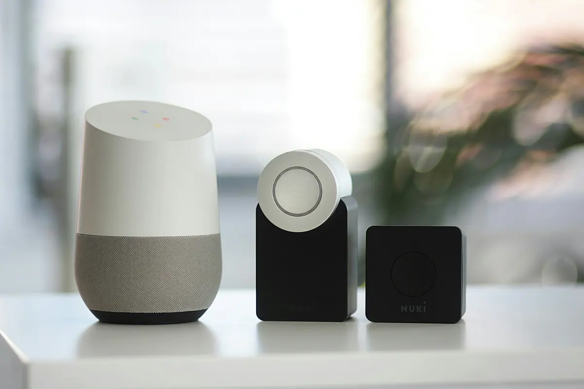 White and gray smart speaker beside two black speakers