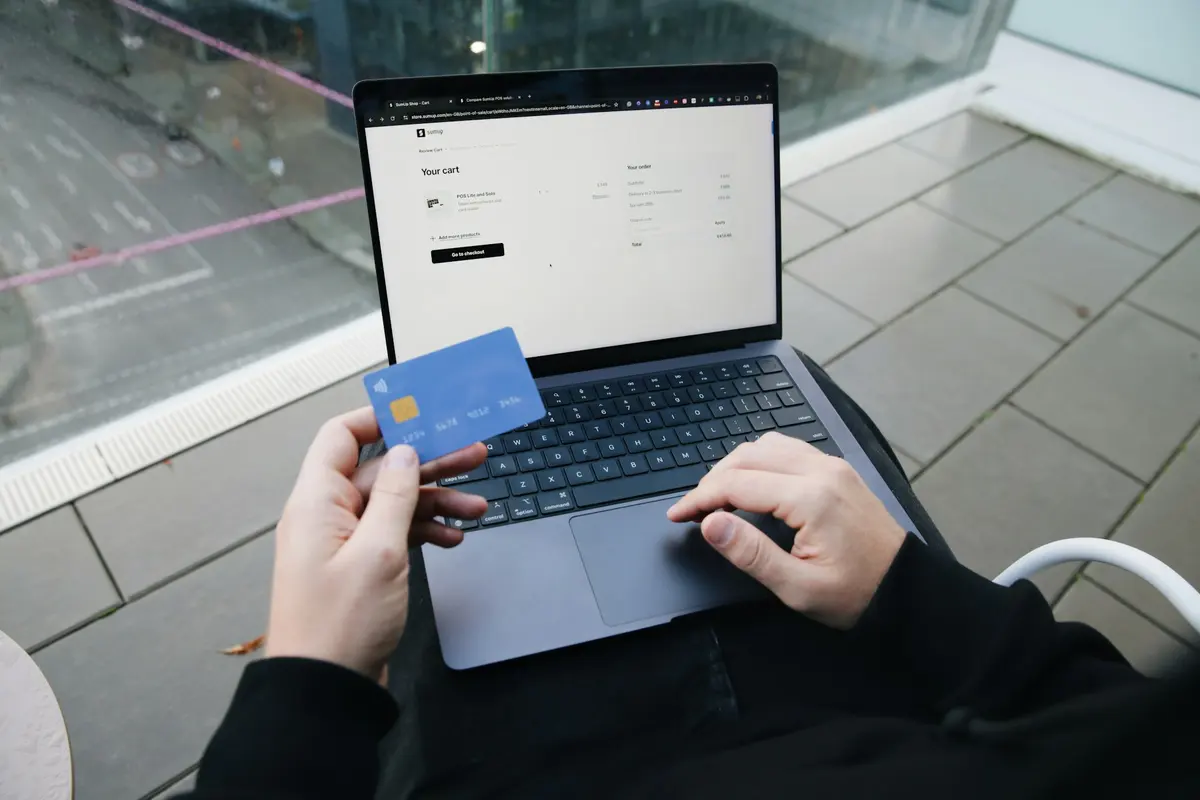 Person sitting with a laptop and a credit card