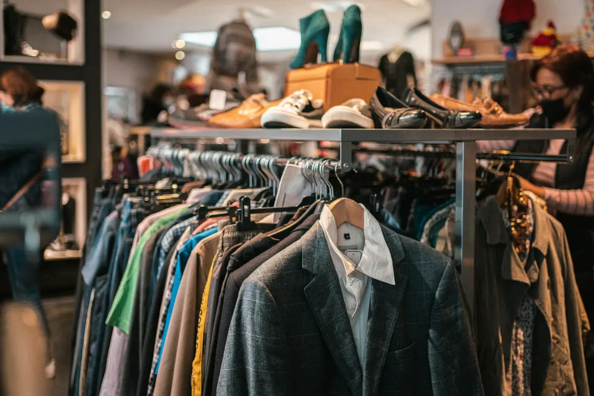 A rack of clothes and shoes in a second-hand store